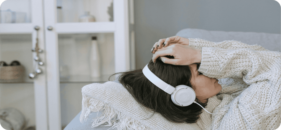 Ležící žena se sluchátky ve stresu.