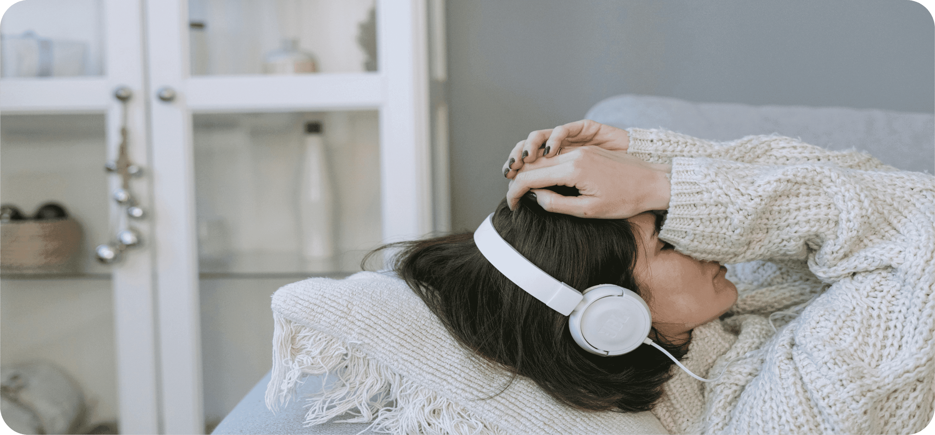 Ležící žena se sluchátky ve stresu.