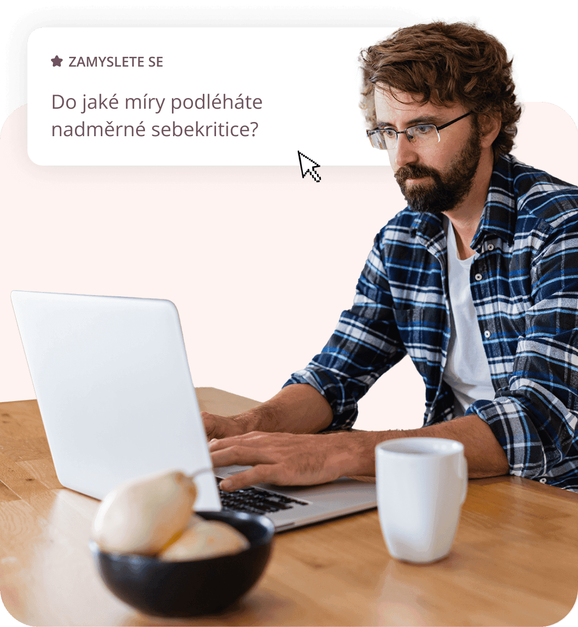 Muž sedící u stolu s počítačem