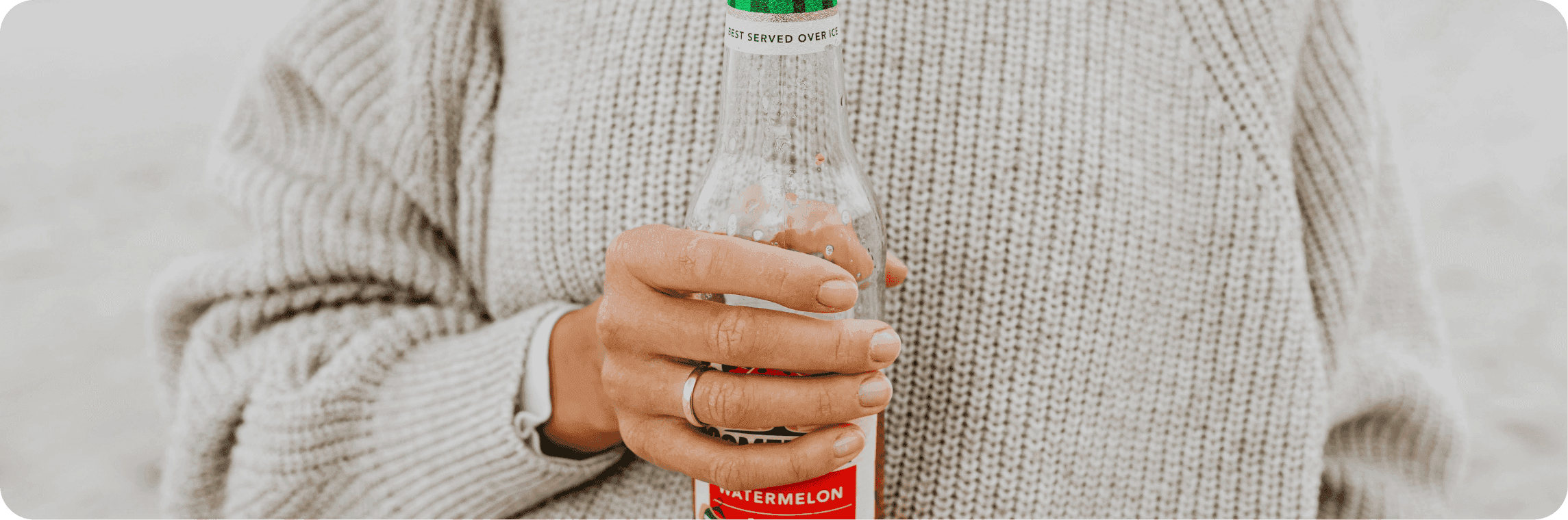 Žena držící skleněnou lahev.