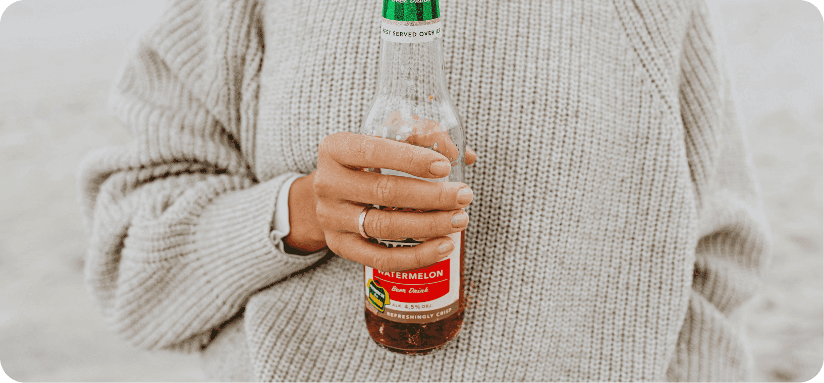 Žena držící skleněnou lahev.