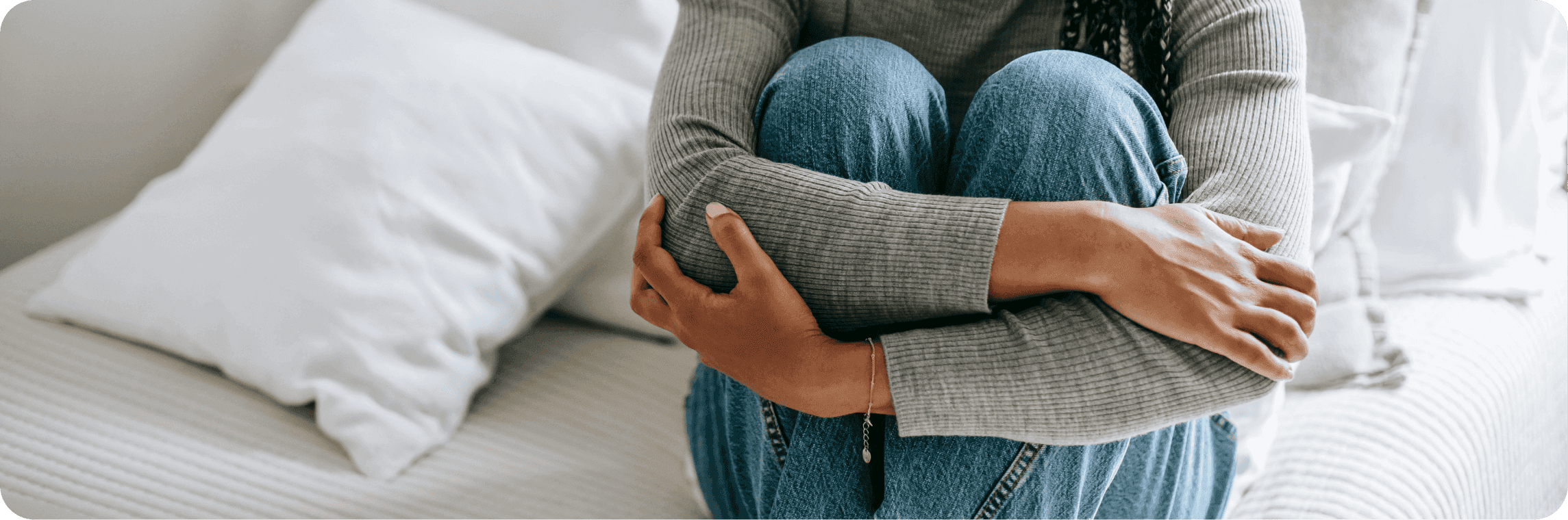 Úzkostná žena sedící na posteli.