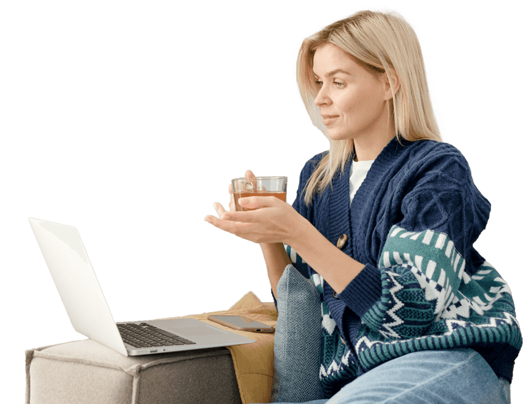 Žena s hrnkem čaje dívající se na počítač