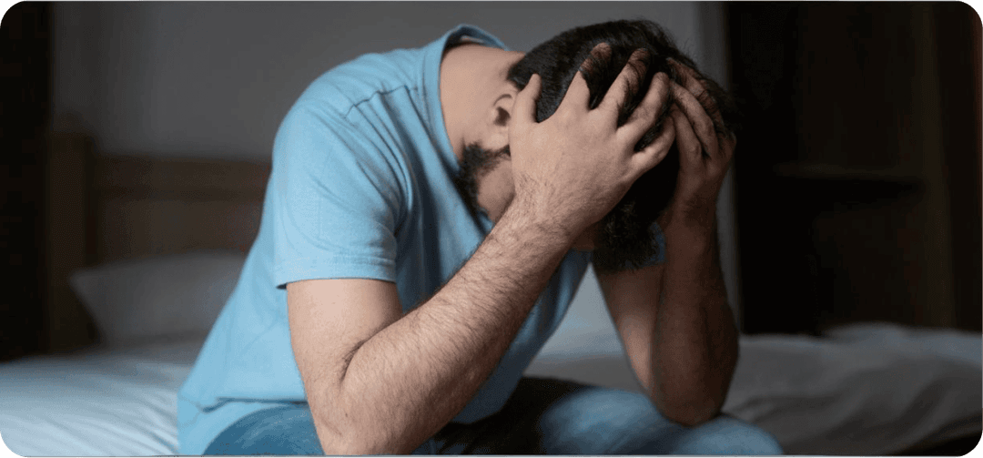 Muž s úzkostně depresivní poruchou držící se za hlavu.